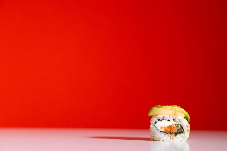 Rollo de sushi sobre fondo rojo Rollo de sushi con verduras de tofu de anguila y primer plano de aguacate