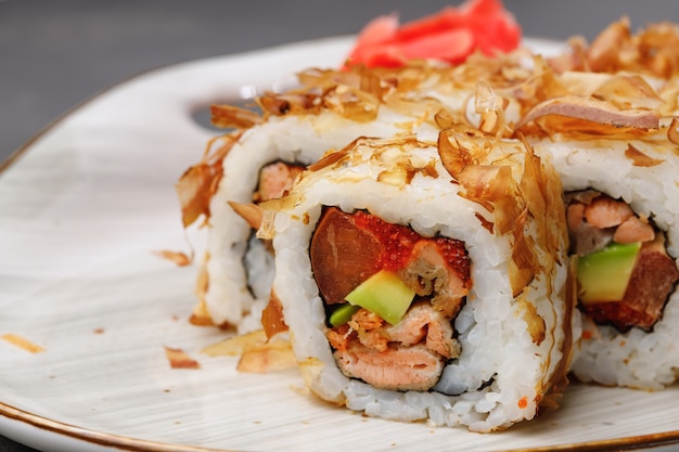 Rollo de sushi con virutas de atún en placa