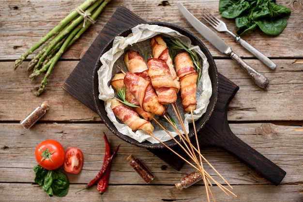 Rollo con tocino y carne picada de pollo en un guiso con espárragos frescos y especias