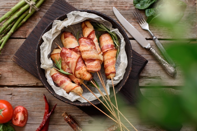 Rollo con tocino y carne picada de pollo en un guiso con espárragos frescos y especias