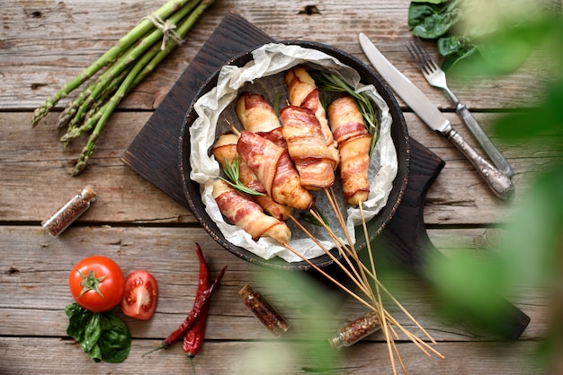 Rollo con tocino y carne picada de pollo en un guiso con espárragos frescos y especias