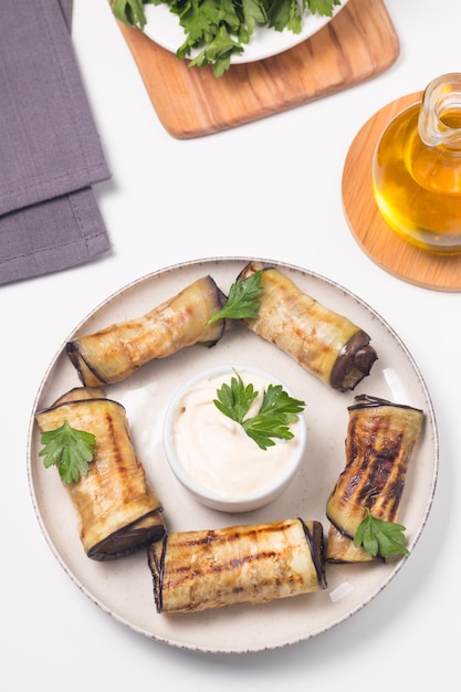 Rollos de berenjena a la parrilla al horno con requesón, tomates y crema agria. Cocina georgiana.