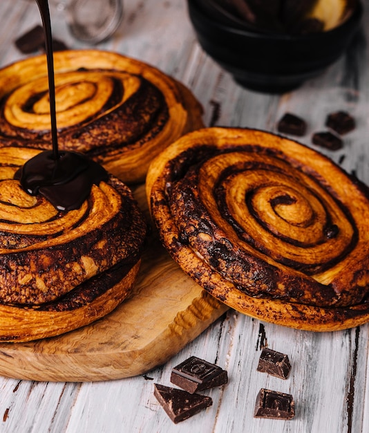 Rollos de canela con chocolate dulce en madera