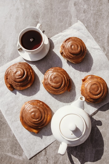 Rollos de canela y crema. Fiesta del té. Naturaleza muerta. Foto vertical.