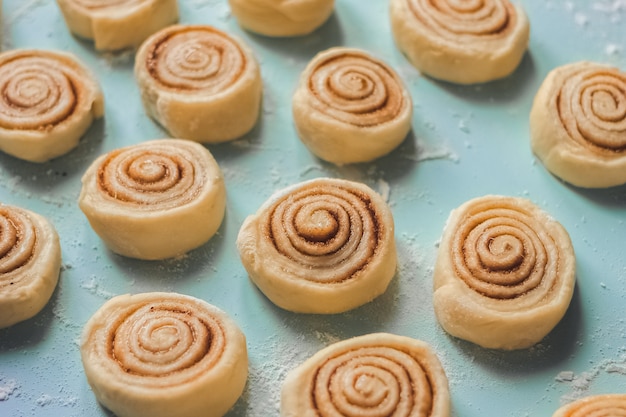 Foto rollos de canela cruda caseros sobre el fondo azul.