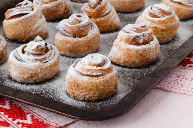 Rollos de canela recién horneados en bandeja de acero para hornear. Bollos de canela caseros para el desayuno