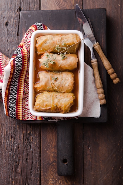 Rollos de carne en col en un plato blanco con salsa