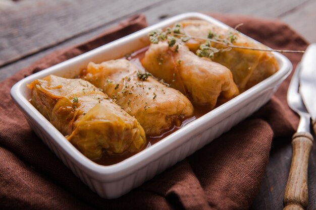 Rollos de carne en col en un plato blanco con salsa