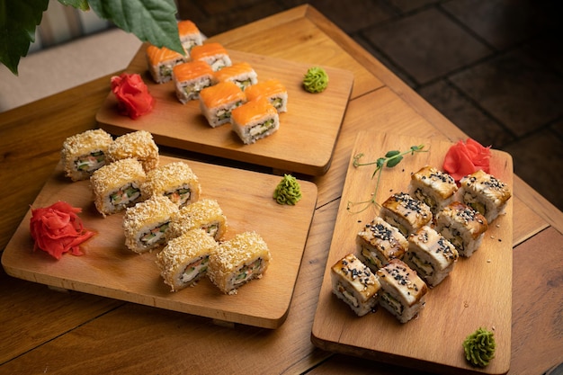 Rollos de cocina japonesa con salsa en un plato de madera