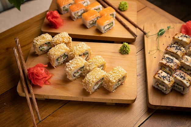 Rollos de cocina japonesa con salsa en un plato de madera