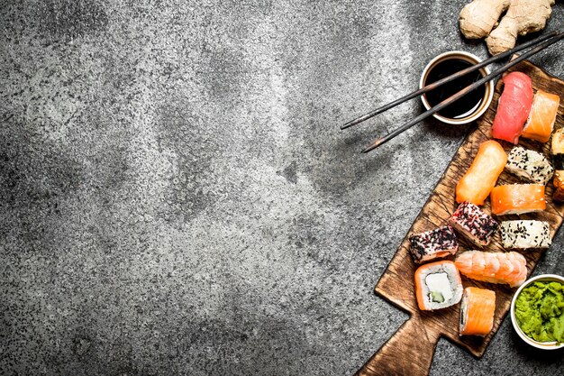 Rollos de comida japonesa fresca con mariscos y salsa de soja sobre fondo rústico