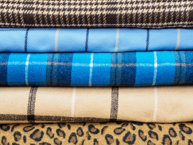 Rollos de diferentes tejidos a cuadros para coser abrigos de cerca.