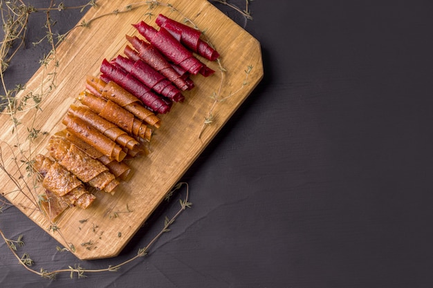 Rollos de fruta en el tablero de madera en negro.