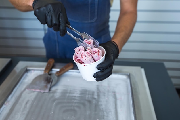 Rollos de helado salteados en una bandeja de congelación Helado enrollado Postre helado hecho a mano