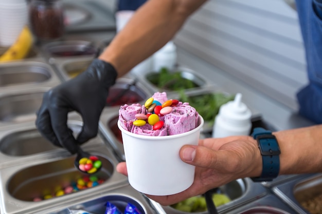 Foto rollos de helado salteados en una bandeja para congelar. helado enrollado, postre helado hecho a mano. máquina de helado frito con sartén refrigerada de acero.
