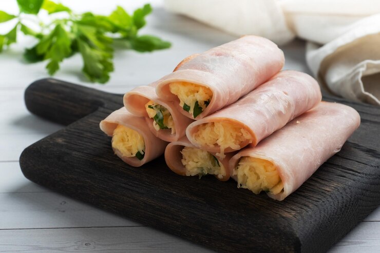 Rollos de jamón y queso en un plato Delicioso aperitivo carbonato de carne y queso crema