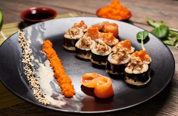 Rollos japoneses originales en el restaurante que sirven con rodajas de pescado caviar semillas de sésamo Vista frontal detallada Receta de plato