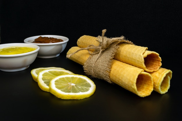 Foto rollos de obleas con leche condensada en un plato blanco.