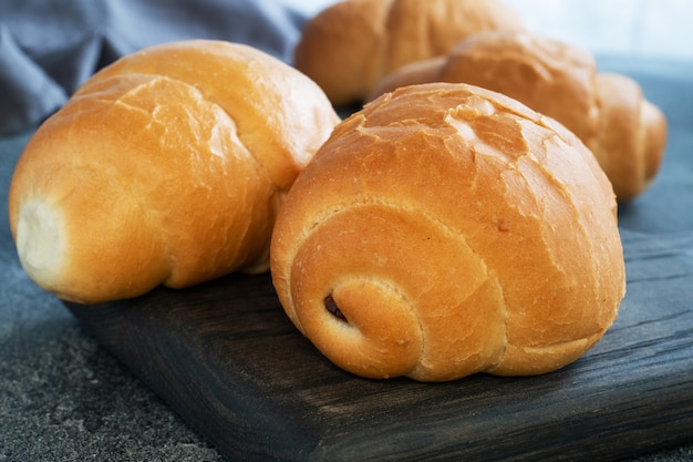 Rollos de pan de trigo fresco. Rollos para un hot dog o hamburguesa. Fondo oscuro copia espacio.