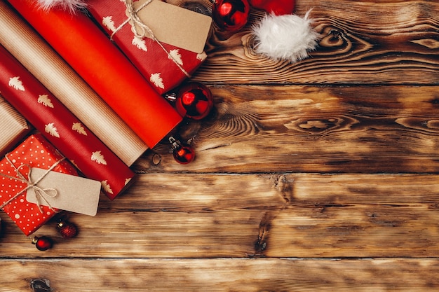 Rollos de papel de embalaje para regalos de Navidad en tablero de madera marrón