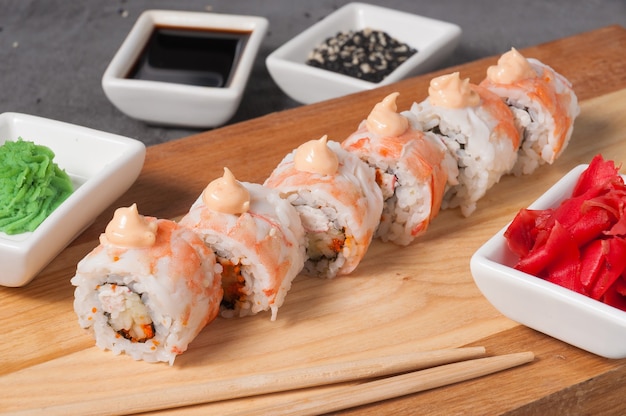 Rollos de sushi con camarones y cangrejo sobre una tabla de madera