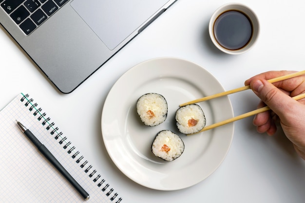 Rollos de sushi comiendo en el trabajo. Tiempo de descanso para comer sushi.