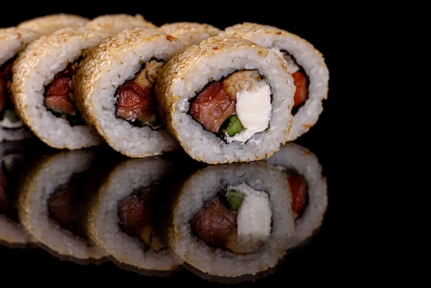 Rollos de sushi delicioso fresco sobre un fondo oscuro