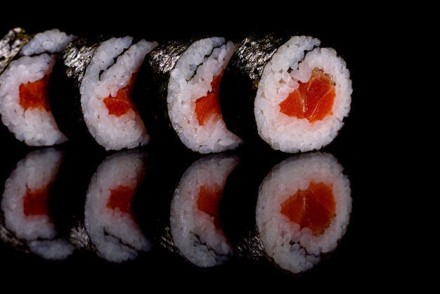 Rollos de sushi delicioso fresco sobre un fondo oscuro