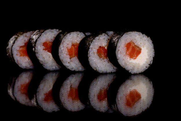 Rollos de sushi delicioso fresco sobre un fondo oscuro