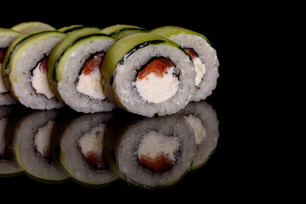 Rollos de sushi delicioso fresco sobre un fondo oscuro