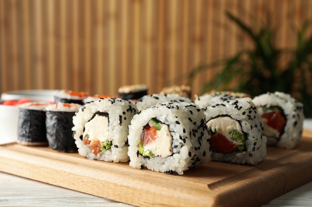 Rollos de sushi deliciosos en la tabla de madera, cierre para arriba. comida japonesa