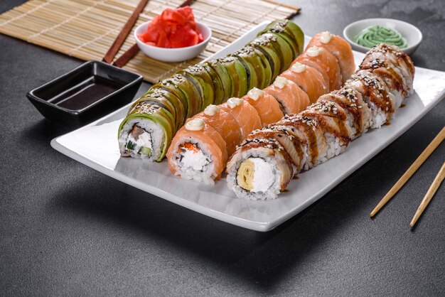 Rollos de sushi frescos y sabrosos dispuestos en forma de dragón con jengibre y wasabi. cocina japonesa