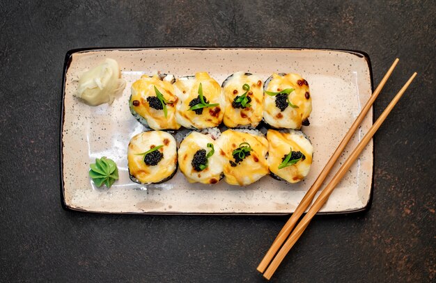 Rollos de sushi japonés al horno sobre un fondo de piedra