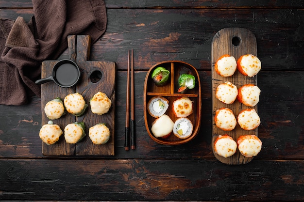 Rollos de sushi japonés llamado Baked Ebi con wasabi y salmón, sobre la vieja mesa de madera oscura.