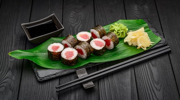 Rollos de sushi maki con atún sobre fondo negro