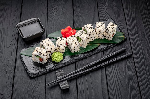 Rollos de sushi maki de cocina tradicional japonesa con queso crema de salmón, aguacate y sésamo