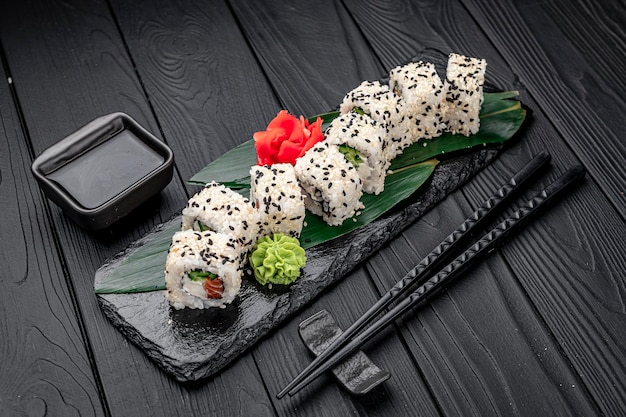 Rollos de sushi maki de cocina tradicional japonesa con queso crema de salmón, aguacate y sésamo