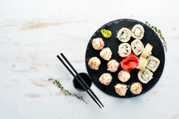 Rollos de sushi y maki en un plato Vista superior Espacio libre para su texto Sobre un fondo blanco