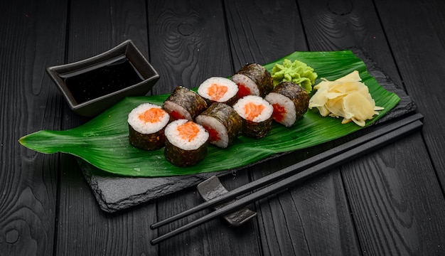 Rollos de sushi maki con salmón sobre fondo negro