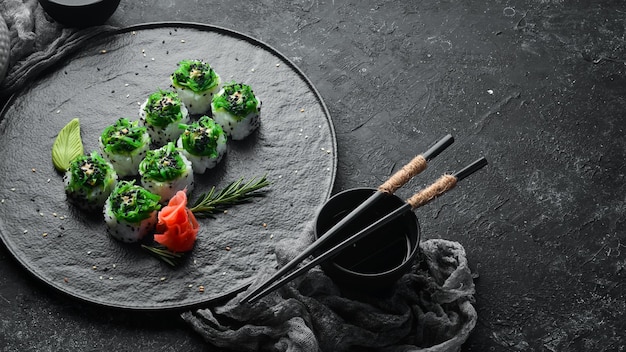 Rollos de sushi con mariscos y ensalada Chuka Sushi verde Vista superior Espacio libre para el texto