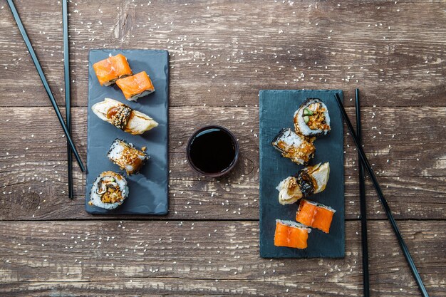 Rollos de sushi de mariscos japoneses y palillos para dos platos