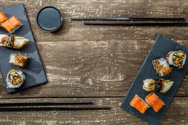 Rollos de sushi de mariscos japoneses y palillos para dos platos