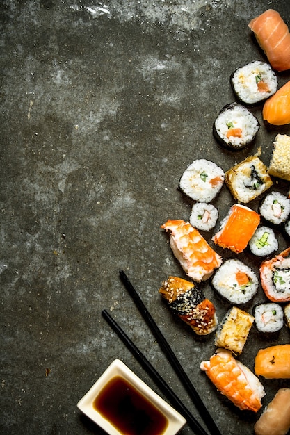 Rollos de sushi con mariscos y salsa de soja. Sobre la mesa de piedra.