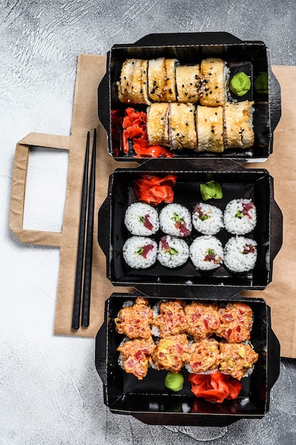 Rollos de sushi en el paquete de entrega, ordenados en un restaurante de sushi para llevar