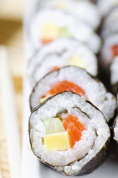 Rollos de sushi con pescado rojo, queso y pepino