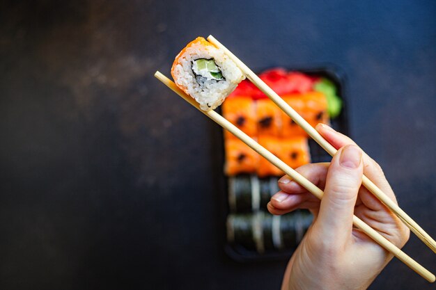 rollos de sushi pescado salmón, verduras, jengibre, arroz wasabi y nori en la mesa