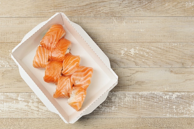 Rollos de sushi con queso Philadelphia y salmón en caja de cartón