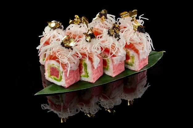 Rollos de sushi con salmón y atún en mamenori con daikon tobiko y oro comestible