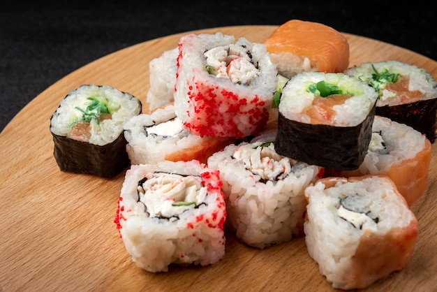 Rollos de sushi sobre fondo negro. Comida japonesa.