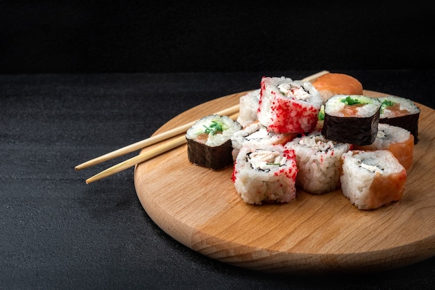 Rollos de sushi sobre fondo negro. Comida japonesa.